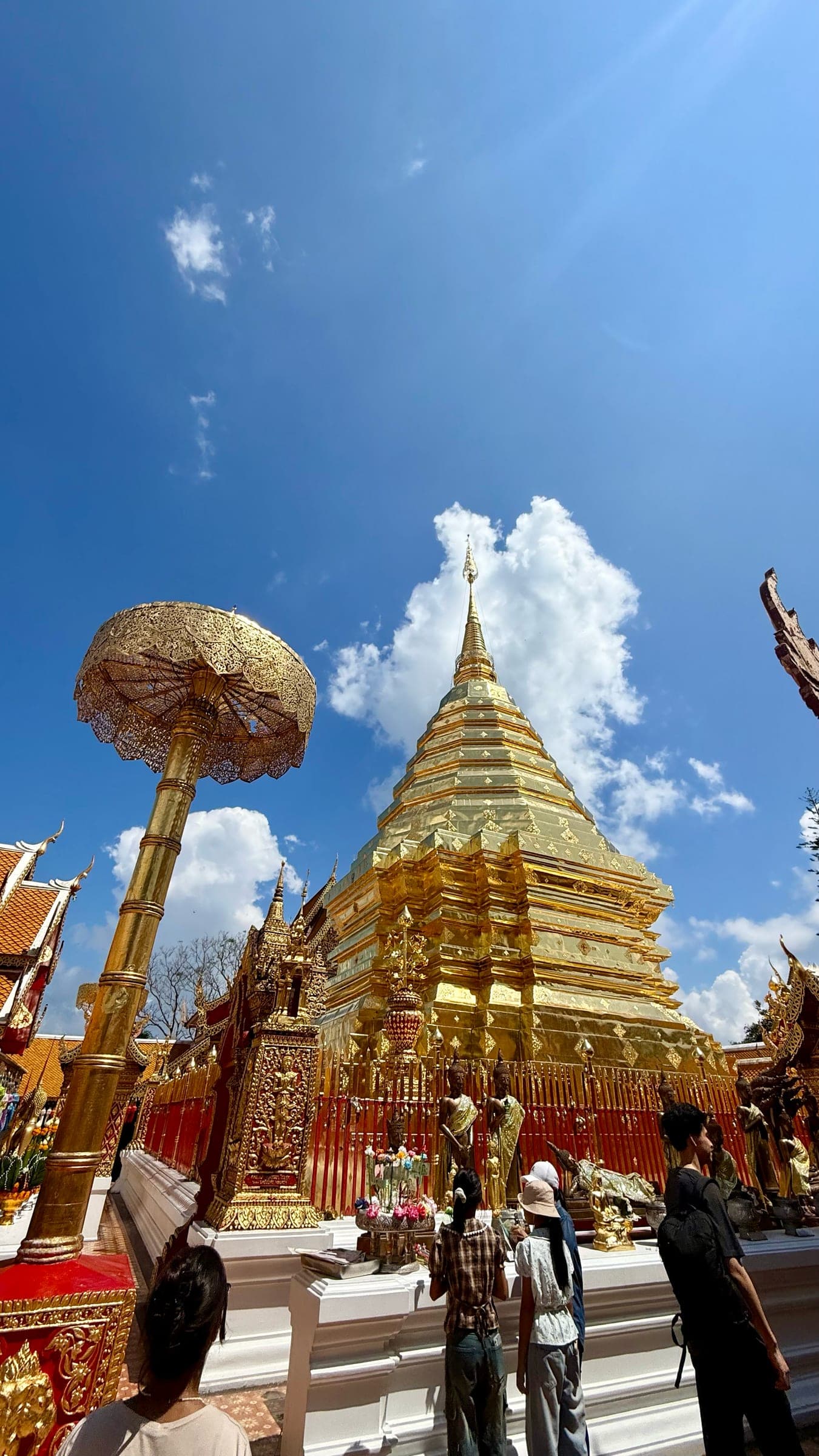 The gilded chedi and golden parasol of Wat Phra That Doi Suthep under a deep blue sky above Chiang Mai