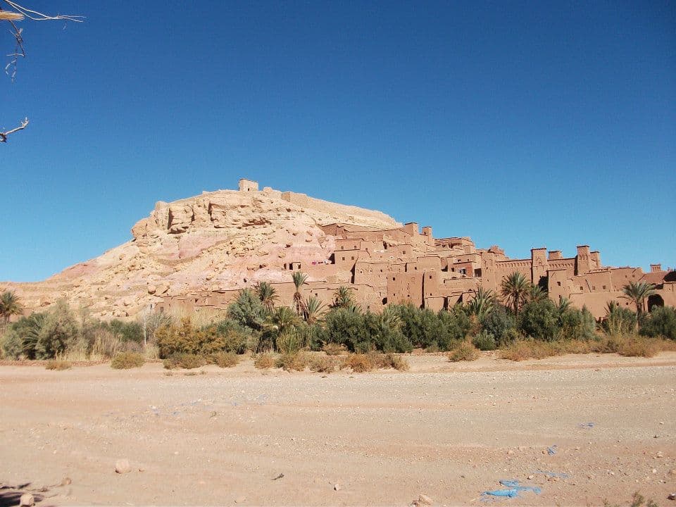 The fortified earthen ksar of Aït Benhaddou stacked up its hillside above a palm grove, southern Morocco