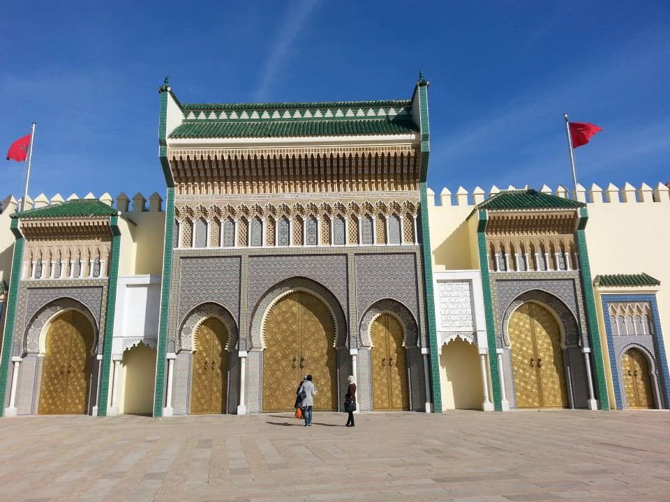 The golden brass doors and zellij tilework of the Royal Palace gates at Place des Alaouites in Fes, Morocco