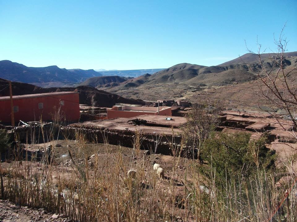 A red-earth Berber village of flat-roofed houses and terraced fields in the Atlas Mountains, Morocco