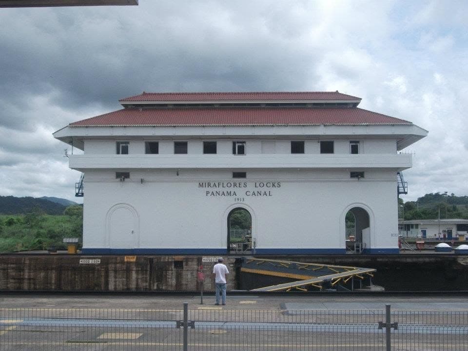 The white control building marked Miraflores Locks Panama Canal 1913, with a red tile roof, above the lock chamber