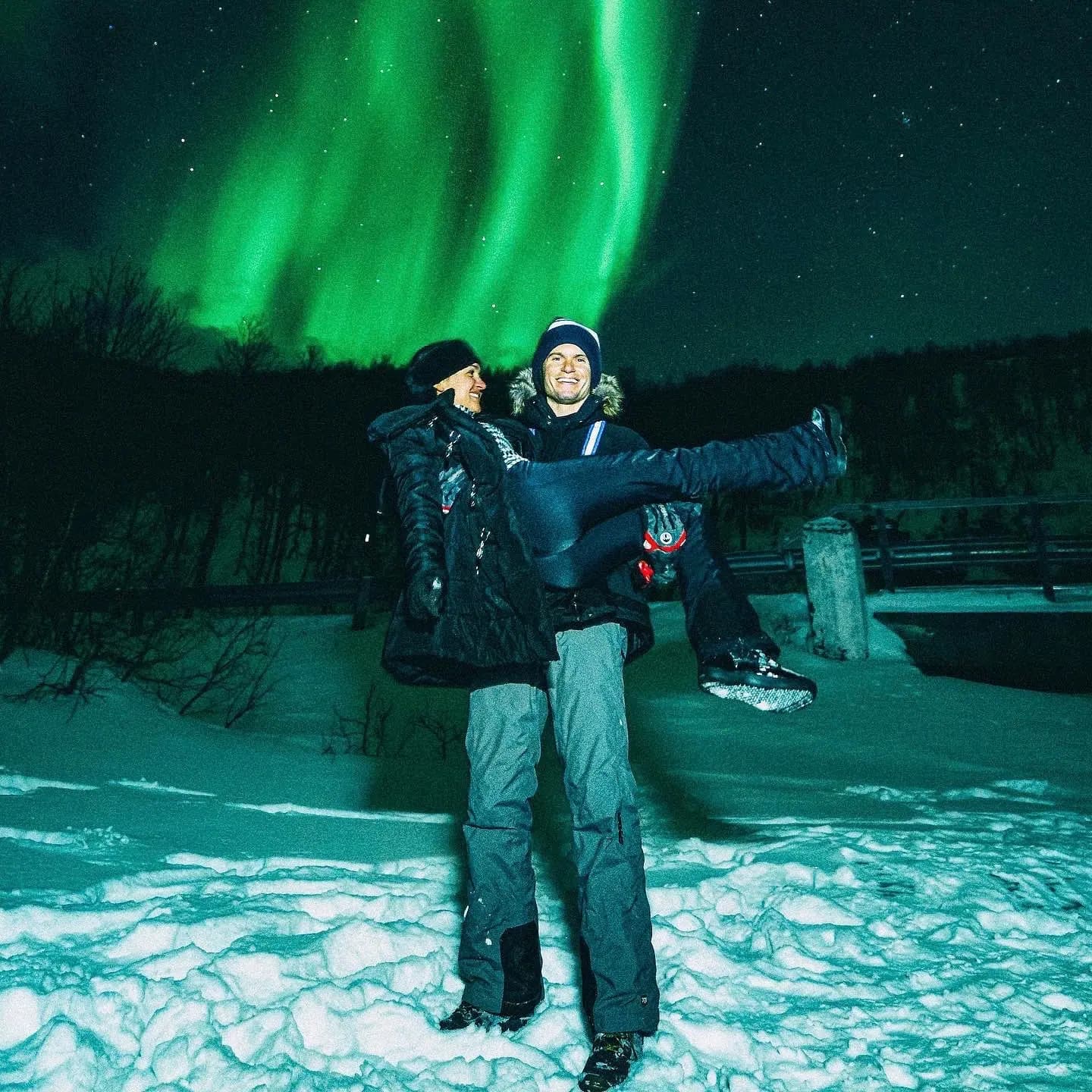 Couple under green northern lights in Tromsø, Norway