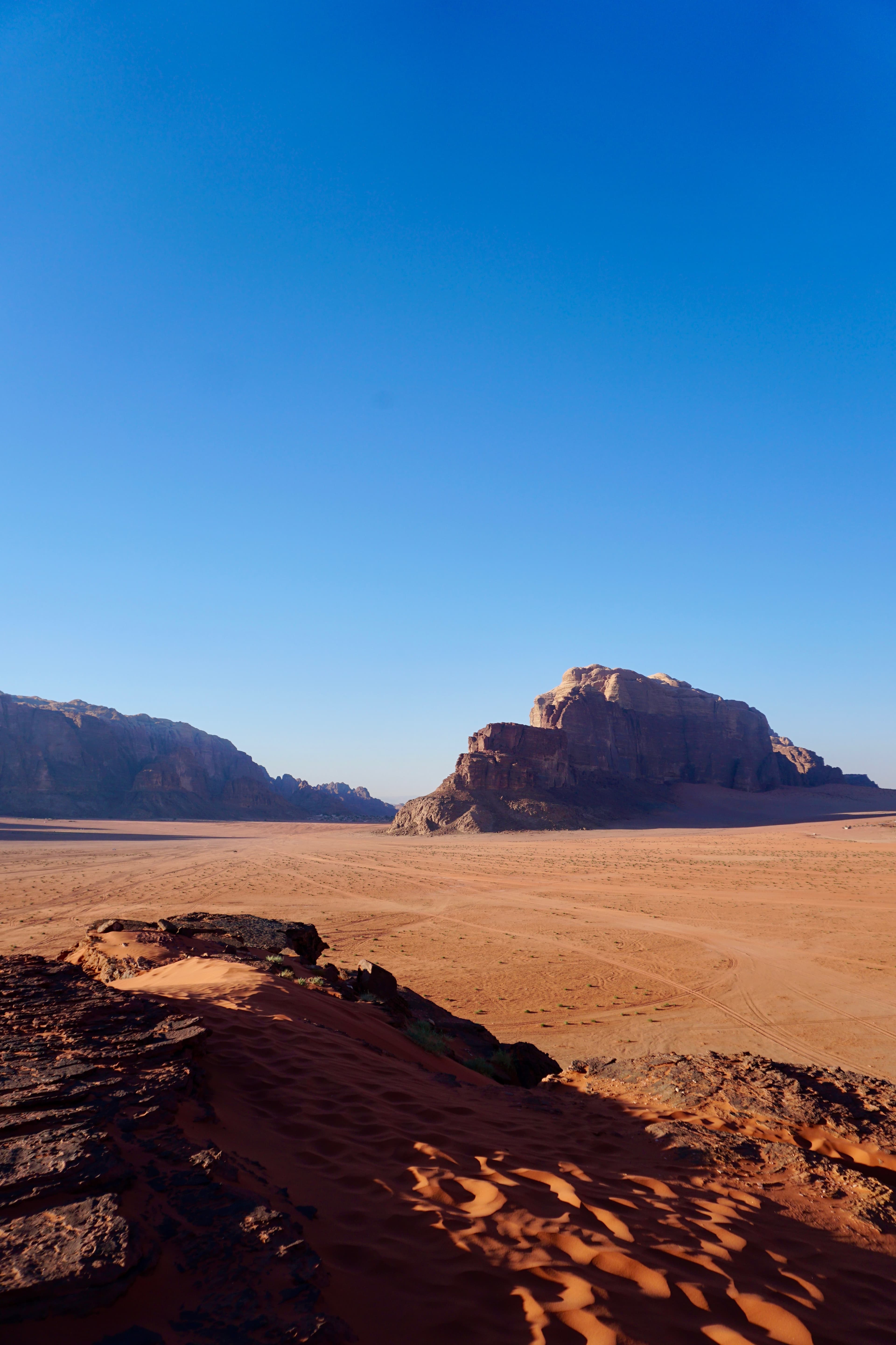 Red sandstone cliffs rising from the desert floor of Wadi Rum, Jordan