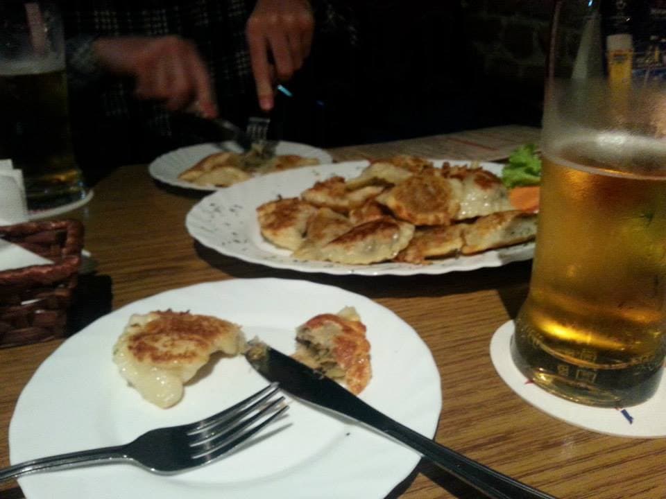 Pan-fried pierogi and glasses of beer at a table in Wrocław